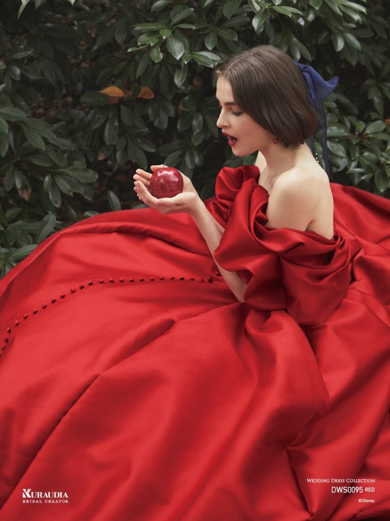 DWS0095（Red）ディズニー ウエディングドレスコレクション | 上質なシルクミカドの美しい赤で「白雪姫」の赤いリップを表現しています。パターンテクニックで魅せるパフスリーブは、りんごの丸いシルエットを表現しています。センターに並ぶくるみボタンはクラシカル感があり、大人の可愛さ漂う一着です。※袖は取り外し可能です。