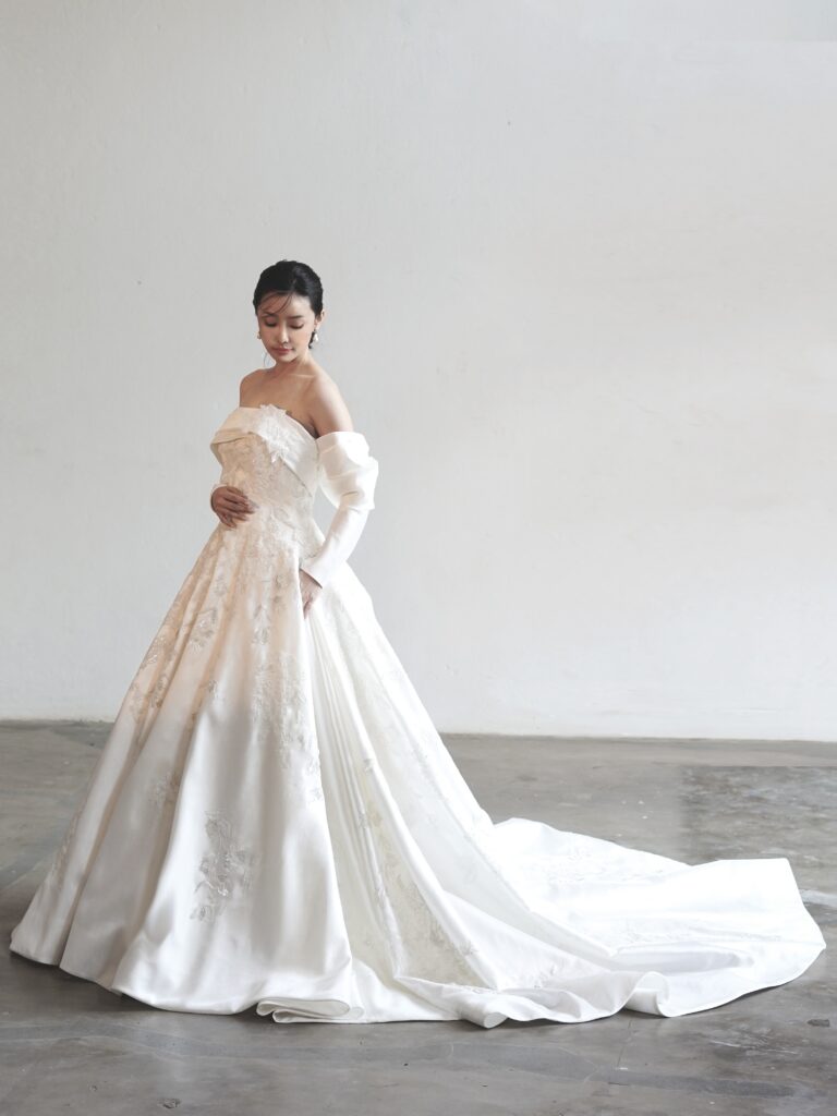 MK-006（オフホワイト） | 光沢感の美しいラメジャガードに580時間の長い時間をかけてパールやビーズを贅沢に手で刺繍した最高級のウエディングドレス✨️
サイドから膨らみを出すことでウエストをより華奢に見せるようなシルエットにもこだわったオートクチュールドレスです💫