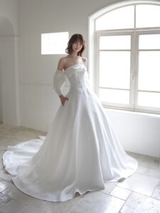 MK-012（オフホワイト）| 独特のとろみがあるトリアセテートミカドをふんだんに使ったAラインのシンプルドレス。スカートの接ぎ線を少なくし、生地の落ち感がスカートのシルエットに表現されるようなカッティングにしました。前中心から後ろにかけて切り替え位置を低くした変形ドロップウエストで、前中心は下にすっきり落ちるデザインでお腹のふくらみをカバーし、脇からボリュームを出すことで華奢なウエストを強調するパターンにこだわった１着です