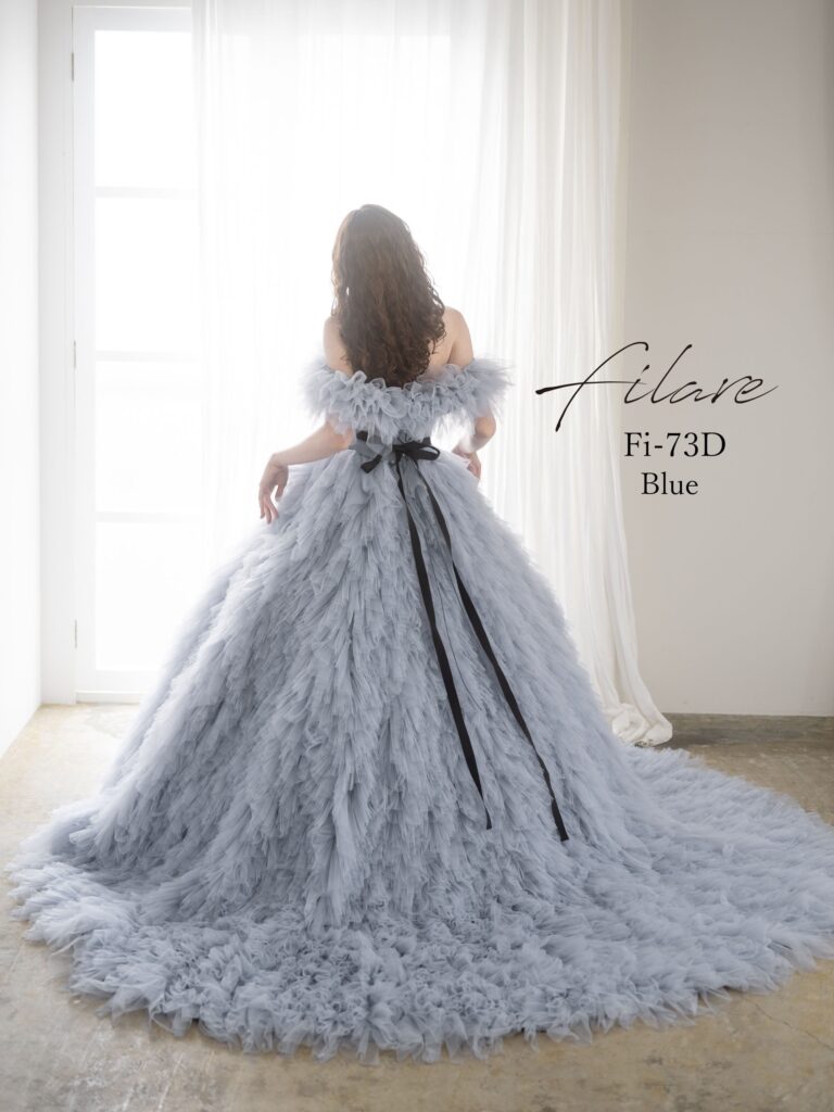 Fi-73Ｄ（ブルー）|繊細なチュールを贅沢に重ねた、立体感のある縦フリルが印象的なボリュームドレス。軽やかに揺れるスカートが、歩くたびに優雅な存在感を放ちます。身頃は肌なじみのよいビスチェラインで、すっきりとした印象に。デコルテから二の腕にかけてふんわりと覆うケープ風のフリルは、華やかさを添えながら気になる部分もやさしくカバー。フェミニンで着やすさにもこだわった、着る人それぞれの魅力を引き立ててくれる、心まで軽やかにしてくれるような一着です。