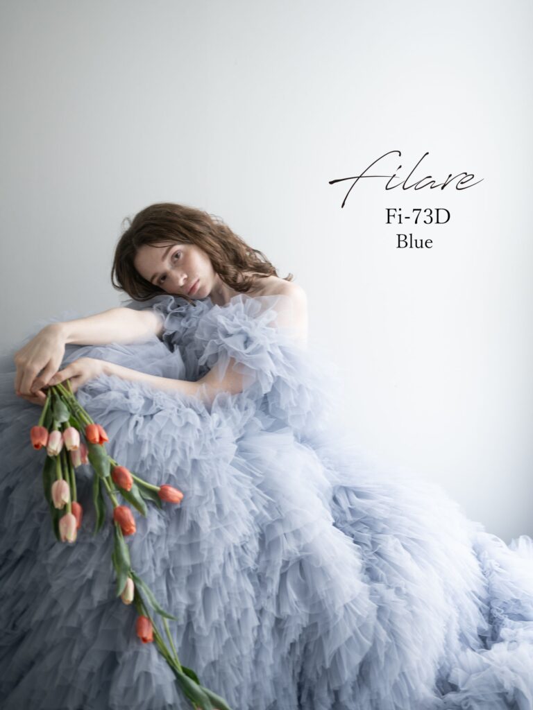 Fi-73Ｄ（ブルー）|繊細なチュールを贅沢に重ねた、立体感のある縦フリルが印象的なボリュームドレス。軽やかに揺れるスカートが、歩くたびに優雅な存在感を放ちます。身頃は肌なじみのよいビスチェラインで、すっきりとした印象に。デコルテから二の腕にかけてふんわりと覆うケープ風のフリルは、華やかさを添えながら気になる部分もやさしくカバー。フェミニンで着やすさにもこだわった、着る人それぞれの魅力を引き立ててくれる、心まで軽やかにしてくれるような一着です。