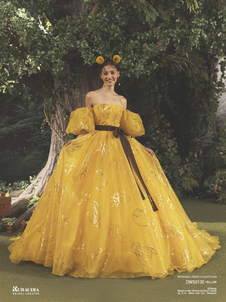 DWS0130 Yellow 「Pooh」| 『くまのプーさん』の仲間たちを箔プリントしたアイコニックドレス。トレンド感のあるパフスリーブが『くまのプーさん』のフォルムを 連想させます。ウエストリボンには『くまのプーさん』の刺繍が施されています。※袖は取り外し可能です。