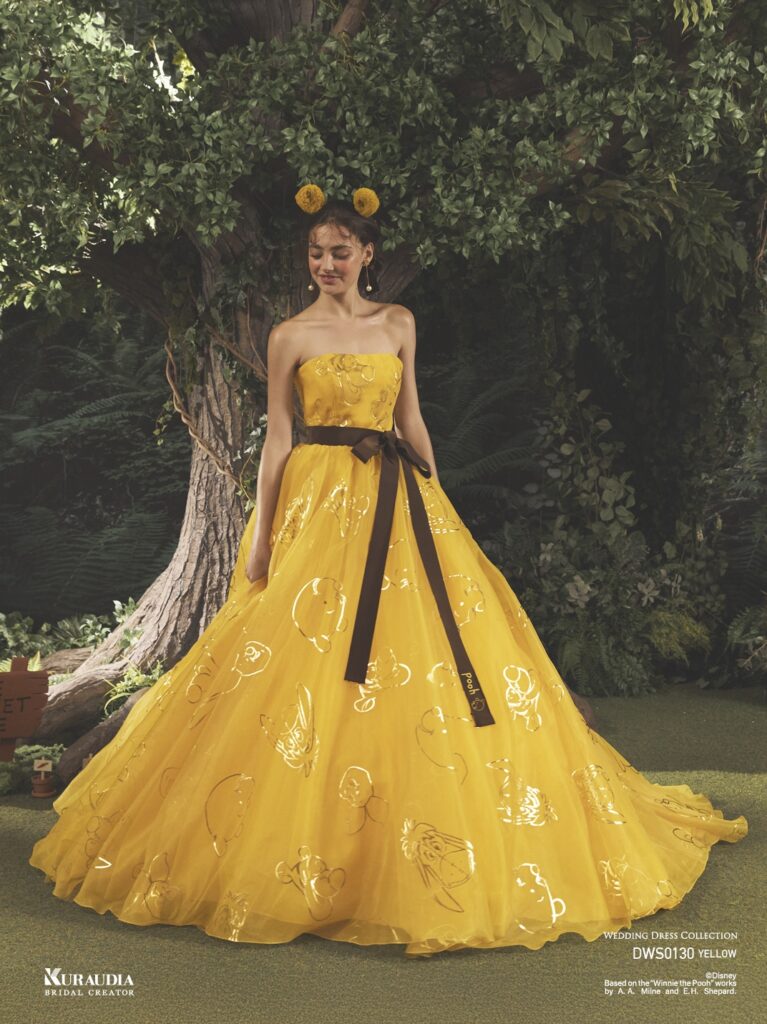 DWS0130 Yellow 「Pooh」| 『くまのプーさん』の仲間たちを箔プリントしたアイコニックドレス。トレンド感のあるパフスリーブが『くまのプーさん』のフォルムを 連想させます。ウエストリボンには『くまのプーさん』の刺繍が施されています。※袖は取り外し可能です。