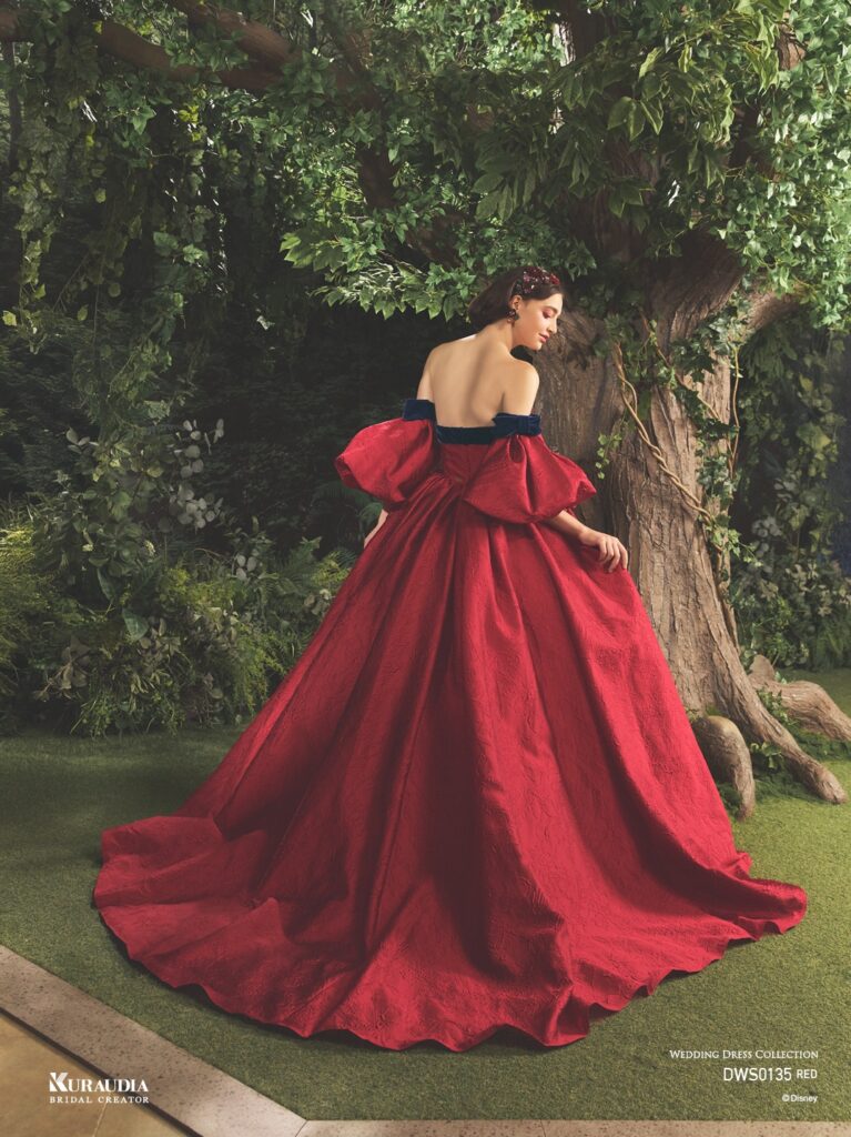 DWS0135 Red 「Snow White」| 「白雪姫」の赤いリップを思わせるジャガード素材を贅沢に使用した、気品あふれる1着です。胸元にはアンティークさを感じる フラワーモチーフと、ネイビーのベルベットリボンをあしらい、「白雪姫」を上品に演出します。りんごのようにふっくらシルエットの パフスリーブも魅力の一つです。※袖は取り外し可能です。