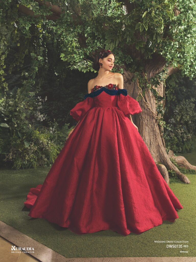 DWS0135 Red 「Snow White」| 「白雪姫」の赤いリップを思わせるジャガード素材を贅沢に使用した、気品あふれる1着です。胸元にはアンティークさを感じる フラワーモチーフと、ネイビーのベルベットリボンをあしらい、「白雪姫」を上品に演出します。りんごのようにふっくらシルエットの パフスリーブも魅力の一つです。※袖は取り外し可能です。