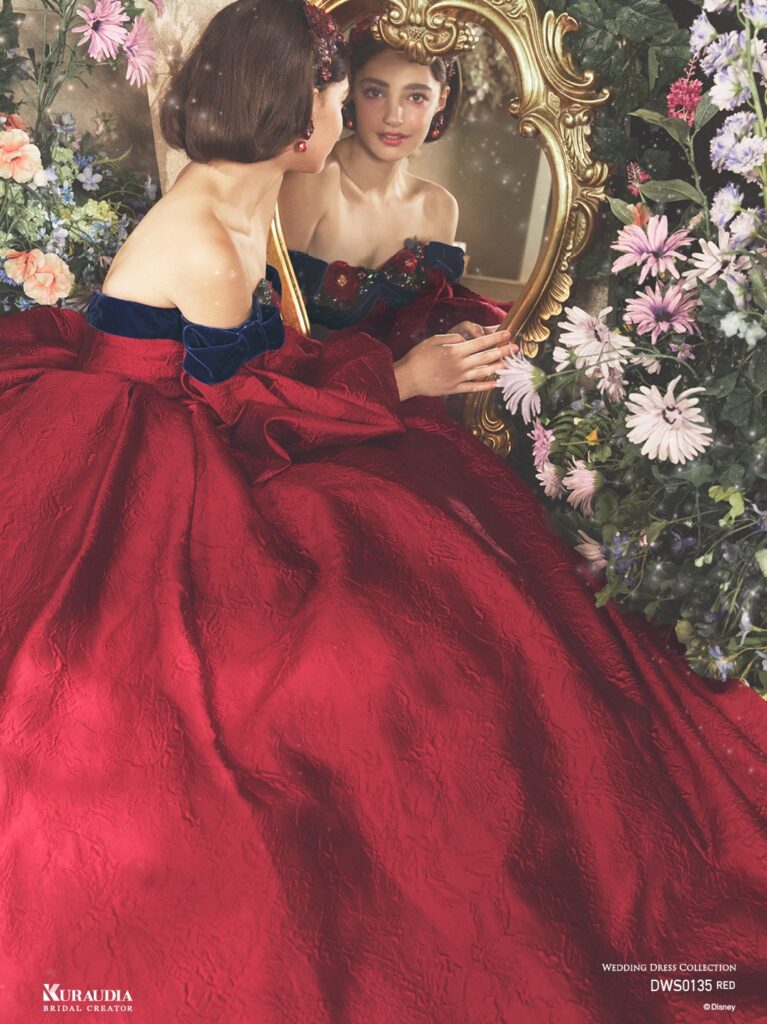 DWS0135 Red 「Snow White」| 「白雪姫」の赤いリップを思わせるジャガード素材を贅沢に使用した、気品あふれる1着です。胸元にはアンティークさを感じる フラワーモチーフと、ネイビーのベルベットリボンをあしらい、「白雪姫」を上品に演出します。りんごのようにふっくらシルエットの パフスリーブも魅力の一つです。※袖は取り外し可能です。