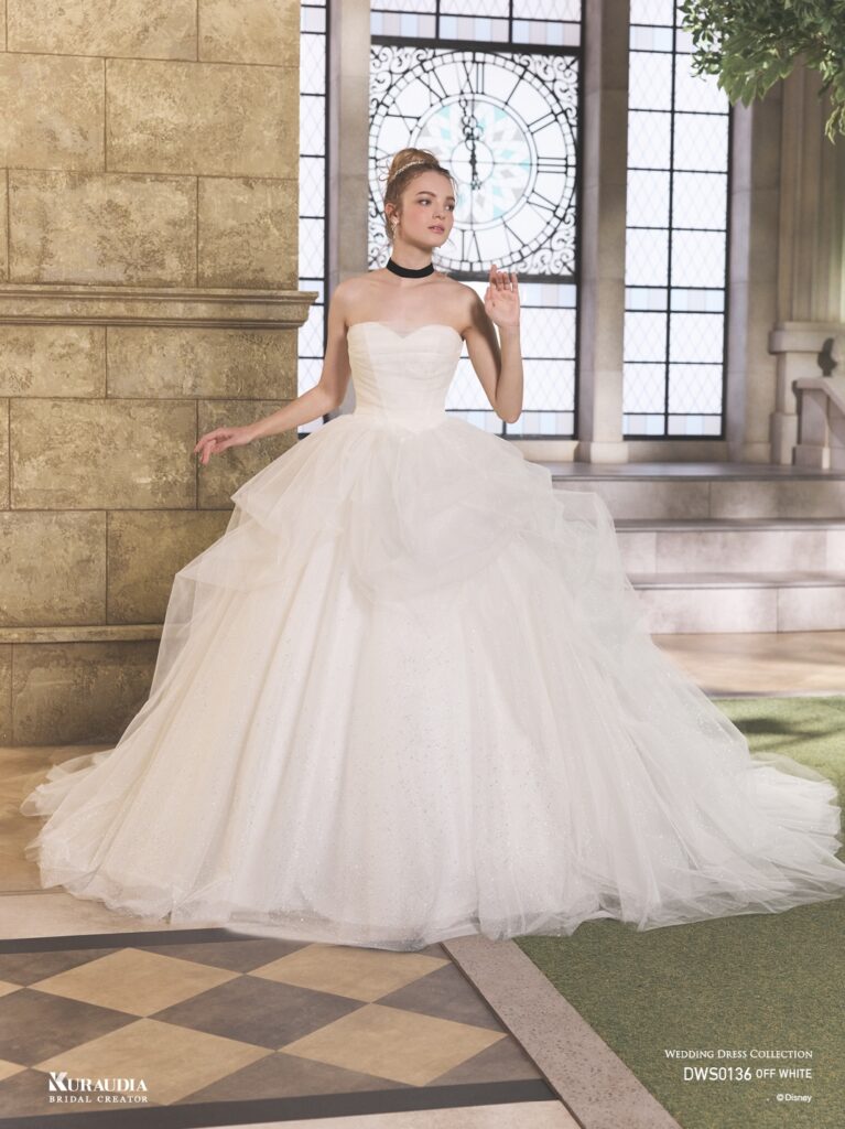 DWS0136 Blue / Off White 「Cinderella」| 「シンデレラ」の魔法にかけられる煌めきを、2種類のグリッターチュールを贅沢に重ね合わせて表現した、ロマンティックな一着 です。「シンデレラ」の衣装からインスパイアされたボリュームのあるタッキングスカートでモードな一面もあります。リボン風の ボリュームショルダーが愛らしさもプラスするプリンセスドレスです。※袖は取り外し可能です。