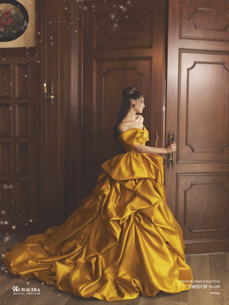 DWS0139 Yellow 「Belle」| 上品なイエローカラーのミカドを贅沢に使用し「ベル」をインスパイアしたドレスです。スカートの左側には、「ベル」を象徴するバラのモチーフが表現されています。オフショルダーやスカートはテクニカルなドレーピングで、洗練された重厚感のある1着です。