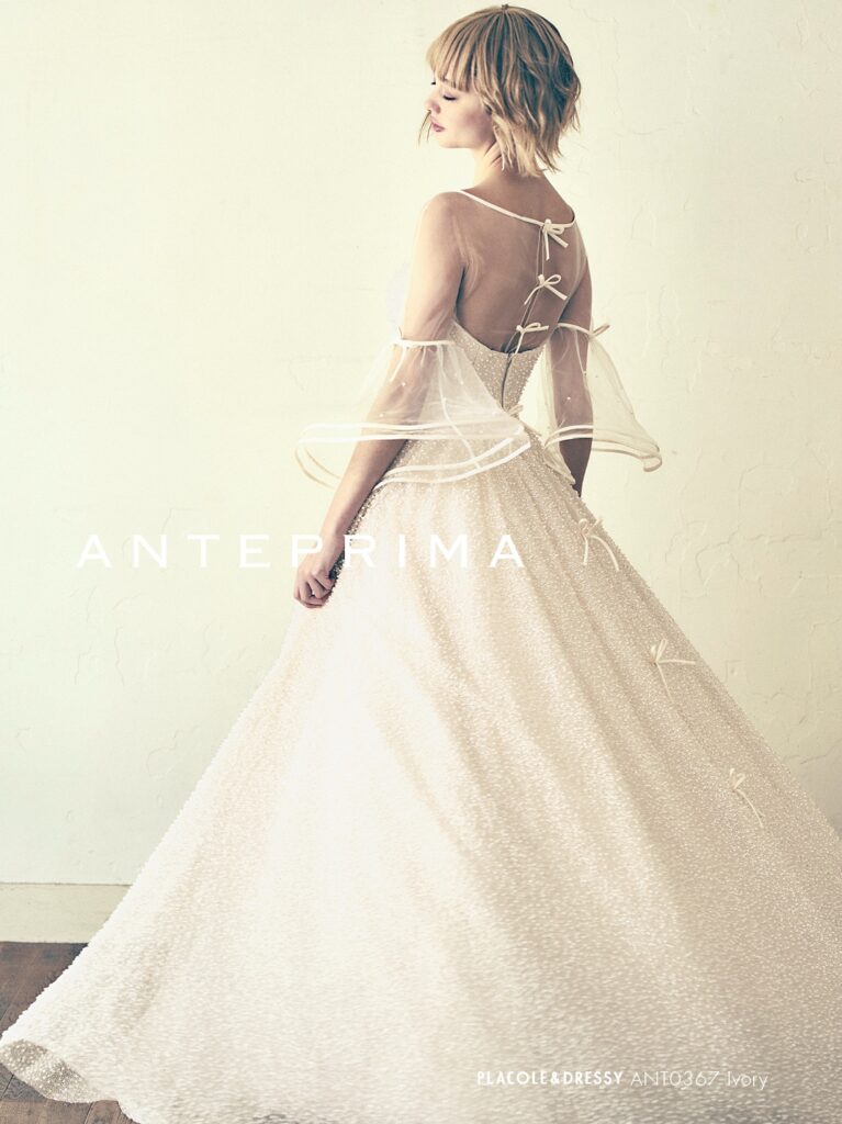 ANT0367(アイボリー/オレンジ) | ジュエルパールグリッターの輝きを全身にまとい、上品さと可憐さをあわせ持つ“現代のプリンセス”を表現。新素材“エアーファブリックオーガン”が、ふんわりと空気を含んだような軽やかなドレープを描きます。ピーチオレンジのやさしい色合いが肌にやわらかく映え、見る人にぬくもりと幸せを届けるような一着です。