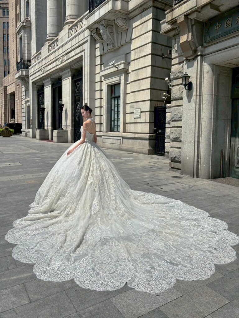 RF-059（アイボリー） | アトリエエム45周年記念ドレスの「Celeste（セレステ）」はアニバーサリードレスにふさわしい圧巻のウェディングドレス。トレーンの長さは圧倒的なロングトレーン、お袖やチョーカーは何通りも変更可。ハンドメイド刺繍にこだわり、異なる2種類エンブロイダリーレースを贅沢に重ね総レースのように仕立ててあります。スパンコールチュール、グリッターチュール、最後にクリスタルビーズを含めた刺繍はドレス全体が宝石のように輝きます✨