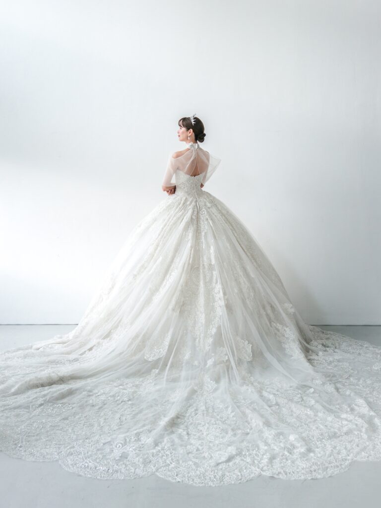 RF-059（アイボリー） | アトリエエム45周年記念ドレスの「Celeste（セレステ）」はアニバーサリードレスにふさわしい圧巻のウェディングドレス。トレーンの長さは圧倒的なロングトレーン、お袖やチョーカーは何通りも変更可。ハンドメイド刺繍にこだわり、異なる2種類エンブロイダリーレースを贅沢に重ね総レースのように仕立ててあります。スパンコールチュール、グリッターチュール、最後にクリスタルビーズを含めた刺繍はドレス全体が宝石のように輝きます✨