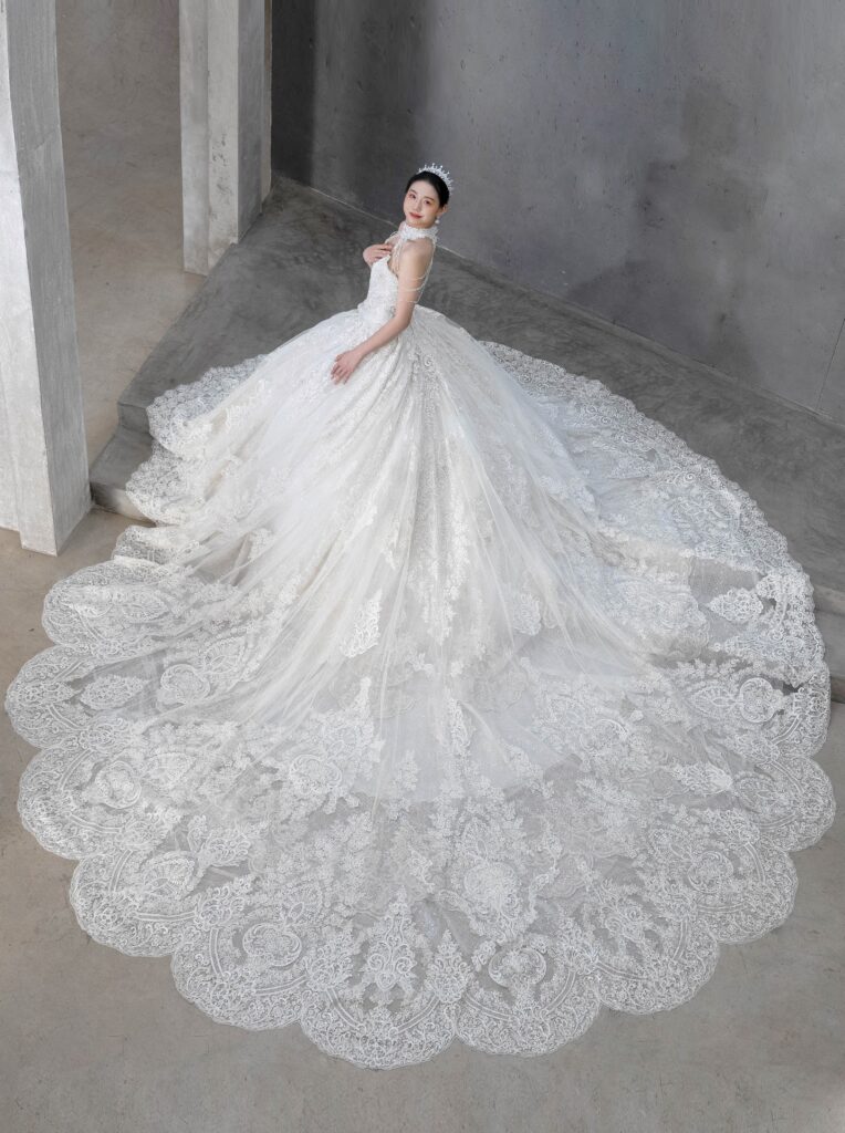 RF-059（アイボリー） | アトリエエム45周年記念ドレスの「Celeste（セレステ）」はアニバーサリードレスにふさわしい圧巻のウェディングドレス。トレーンの長さは圧倒的なロングトレーン、お袖やチョーカーは何通りも変更可。ハンドメイド刺繍にこだわり、異なる2種類エンブロイダリーレースを贅沢に重ね総レースのように仕立ててあります。スパンコールチュール、グリッターチュール、最後にクリスタルビーズを含めた刺繍はドレス全体が宝石のように輝きます✨